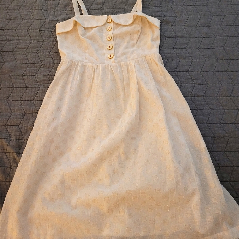 White dress with gold detailing by Maeve
